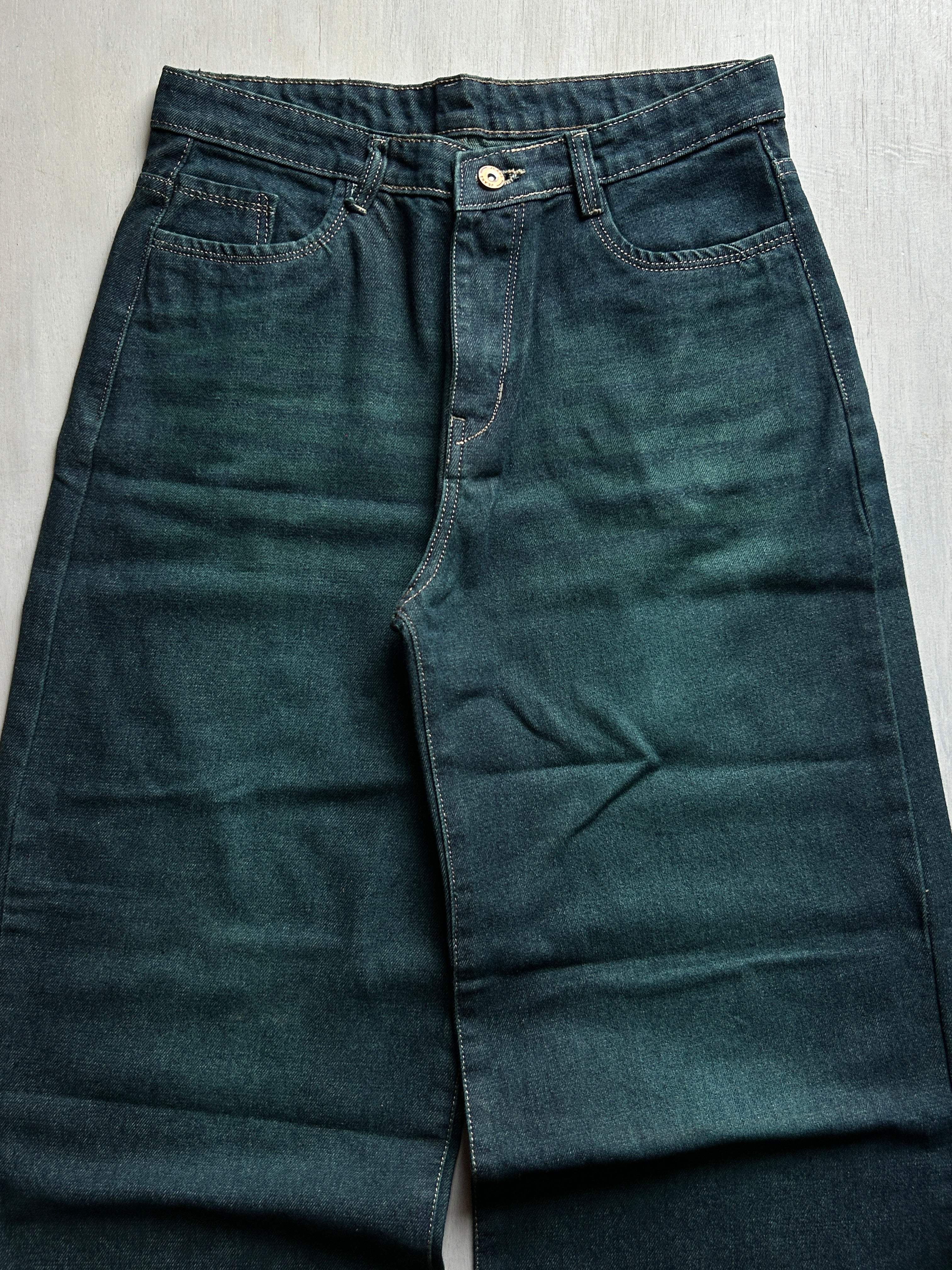Dark blue jeans on a light gray surface